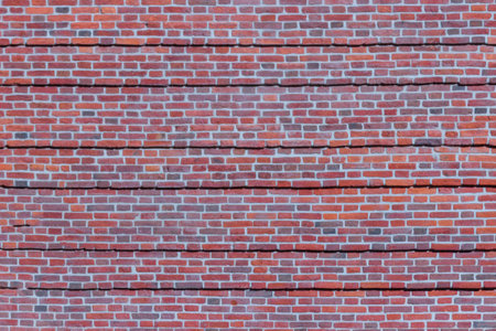 A wide brick blank wall of an old building. Uneven brickwork on a large wall.の写真素材