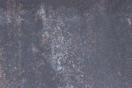 The weathered surface of the chipboard sheet, faded under the sun. Mottled structure with fine...