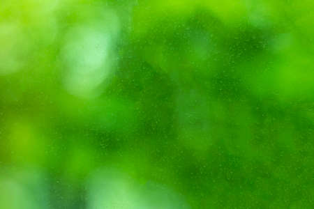 The surface of a window pane stained and streaked by dried raindrops. Blurred texture with smooth...