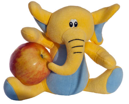 toy elephant holds an apple in white backgroundの写真素材