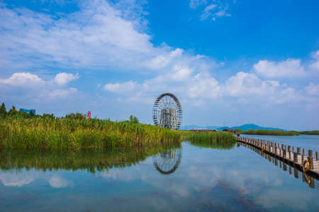 Landscape view of a water mill at the lake under the blue skyの写真素材