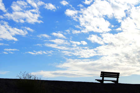 Empty chair silhouette under blue skyの写真素材
