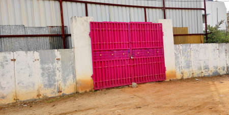 pink metal gate of a closed warehouse.の写真素材