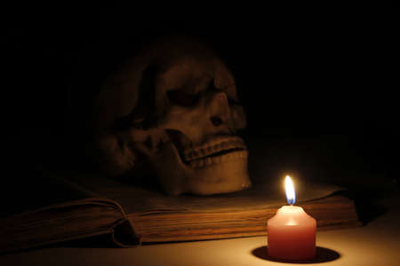 Halloween images, burning candles in an ancient skull and book の写真素材