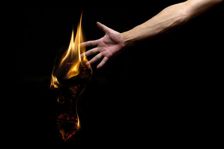 Black background, men arm, burning into ashes heart, lost love from my hands, desperate partingの写真素材