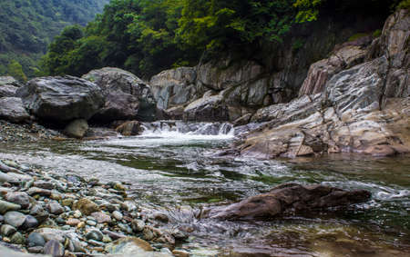 The stream from the mountain rocks in swift flowingの写真素材