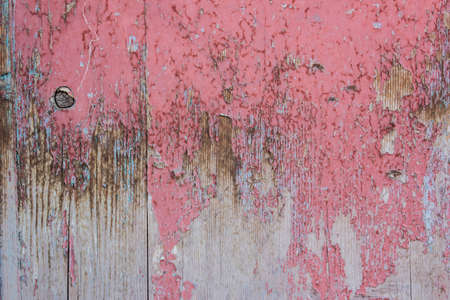 Red and grey color mottled paint weathering cracked wooden close-upの写真素材