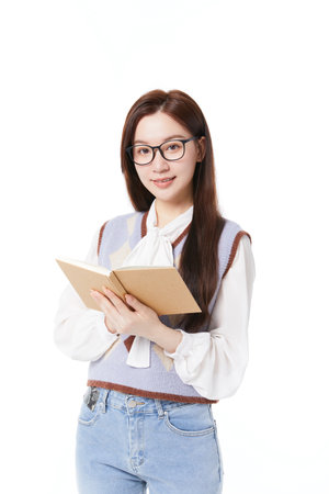 Schoolgirl holding books standing on white backgroundの写真素材
