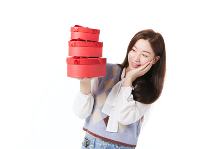A female hand holds a stack of gift boxesの写真素材
