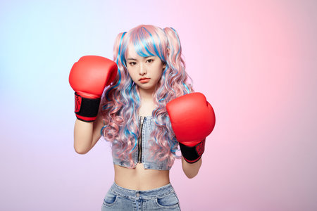 Beautiful woman in stylish wig wearing boxing glovesの写真素材