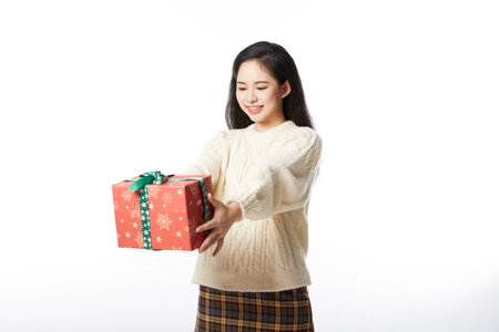 Young female hands out a Christmas giftの写真素材