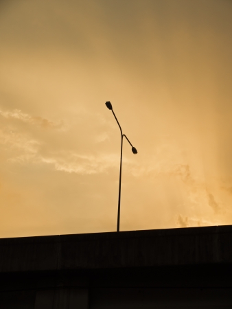 a streetlamp silhouette on the motorway at sunsetの写真素材
