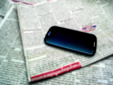 Blur newspaper background and Smartphoneの写真素材
