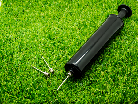 Metal inflation needle for inflatables and athletic balls included heavy duty pump on the grassの写真素材