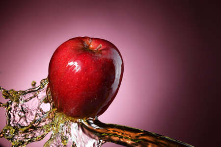 red apple in juice streamの写真素材