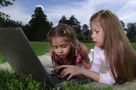 two beauty girl with laptop outdoors