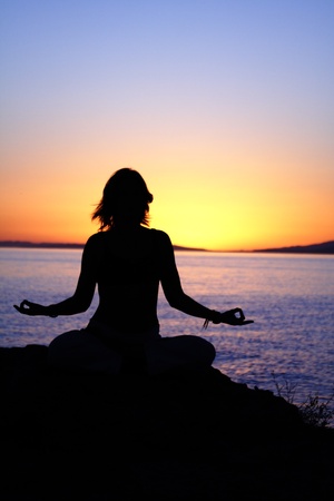 beauty girl in lotus pose on sunrise beachの写真素材