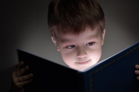 little boy reading a bookの写真素材