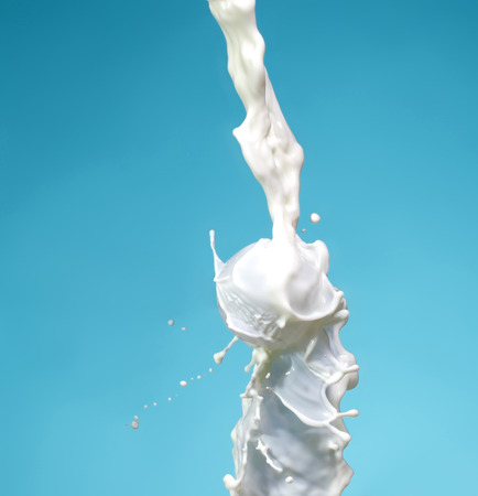 milk splash on blue backgroundの写真素材