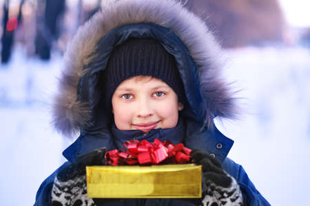 Happy boy with gift box outdoors の写真素材