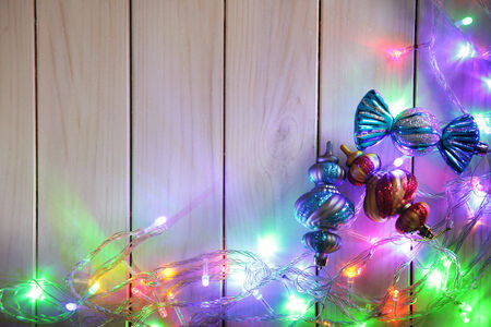 Christmas garlands of lamps on a wooden background. Frame of Christmas lights
