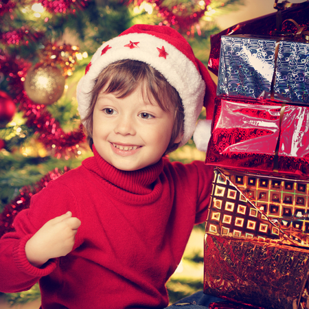 happy boy with christmas gift near Christmas treeの写真素材