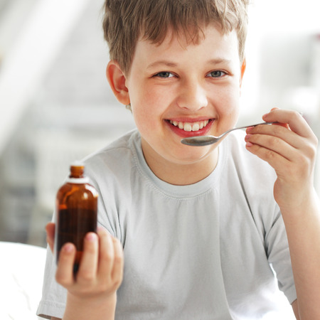happy boy drinking cough syrupの写真素材