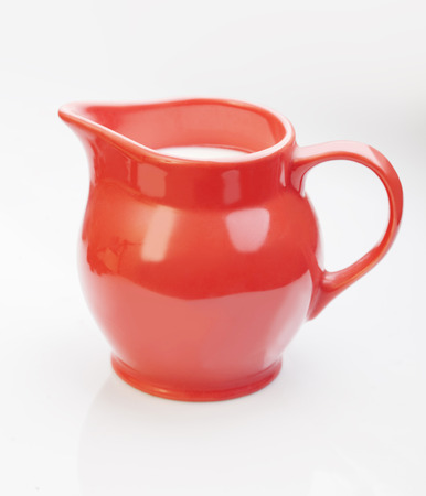 red jug with milk isolate on whiteの写真素材