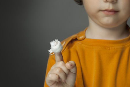 boy with a bandaged wound on his fingerの写真素材