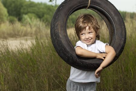 happy boy on swing outdoorsの写真素材