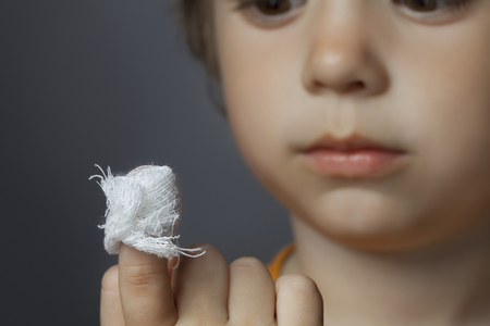 boy with a bandaged wound on his finger (focus on finger)の写真素材