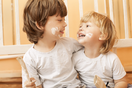 Two stained child with brushes homeの写真素材