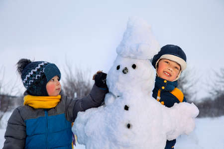 boys with snow man outdoorsの写真素材