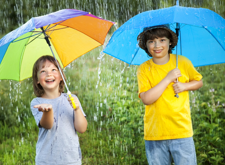 two happy brother with umbrella summer outdoorsの写真素材