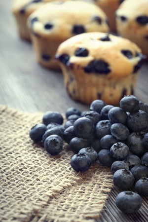 muffin with blueberries on a wooden table. fresh berries and sweet pastries on the boardの写真素材