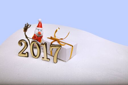 Christmas snowman in the snow is new in 2017 against the backdrop of snowflakes and illumination