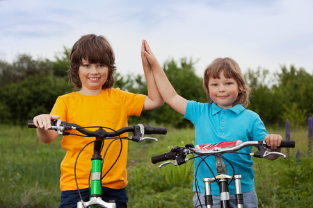 two brothers ride bikes outdoorsの写真素材