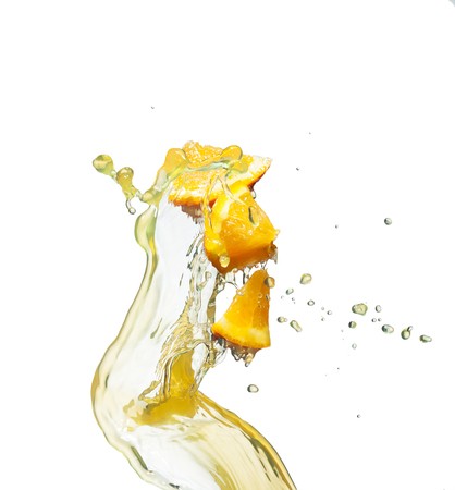 orange slice in juice stream on whiteの写真素材