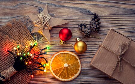 Christmas gift box and decorations on wooden background copy space for lettering top view.