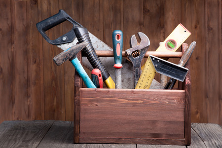 grungy old tools on a wooden background.