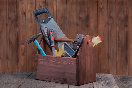 grungy old tools on a wooden background.