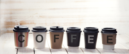 Word of coffee paper cup on on wooden table. letter on cupの写真素材