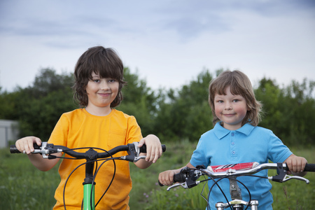 two brothers ride bikes outdoorsの写真素材