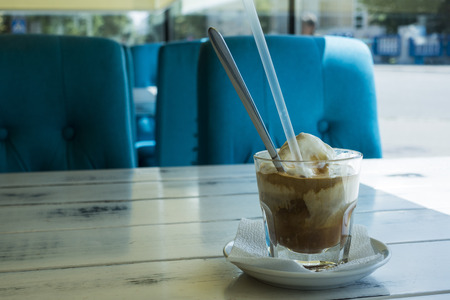 Caramel frappe coffee in the cafe, Ice beverage in a tall glass with cream. with latte macchiato.