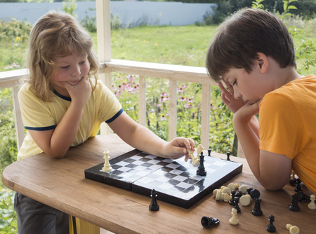 Child playing chess outdors, Young boy making a move.