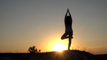 Silhouette young woman practicing yoga and Meditation at sunset.の写真素材