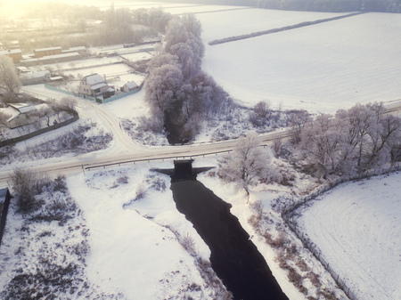 Aerial view of forest and river covered with snowの写真素材