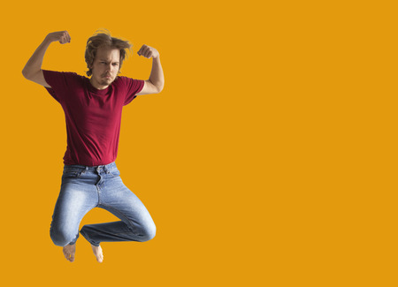Teenager boy jumping dance movement on a colored yellow