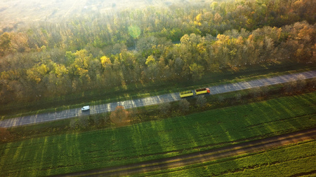 Aerial Top View of White Truck with Cargo Semi Trailer Moving on Road in Direction.の写真素材
