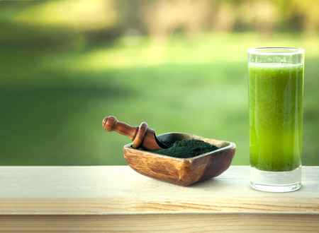 Green smoothie with spirulina on woodの写真素材